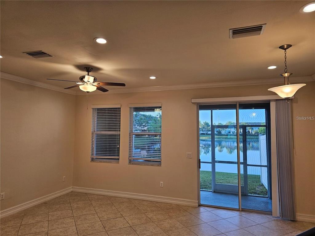 A living area features tile flooring, a ceiling fan, recessed lighting, and sliding glass doors — 3216 PAINTED BLOSSOM COURT, LUTZ, FL
