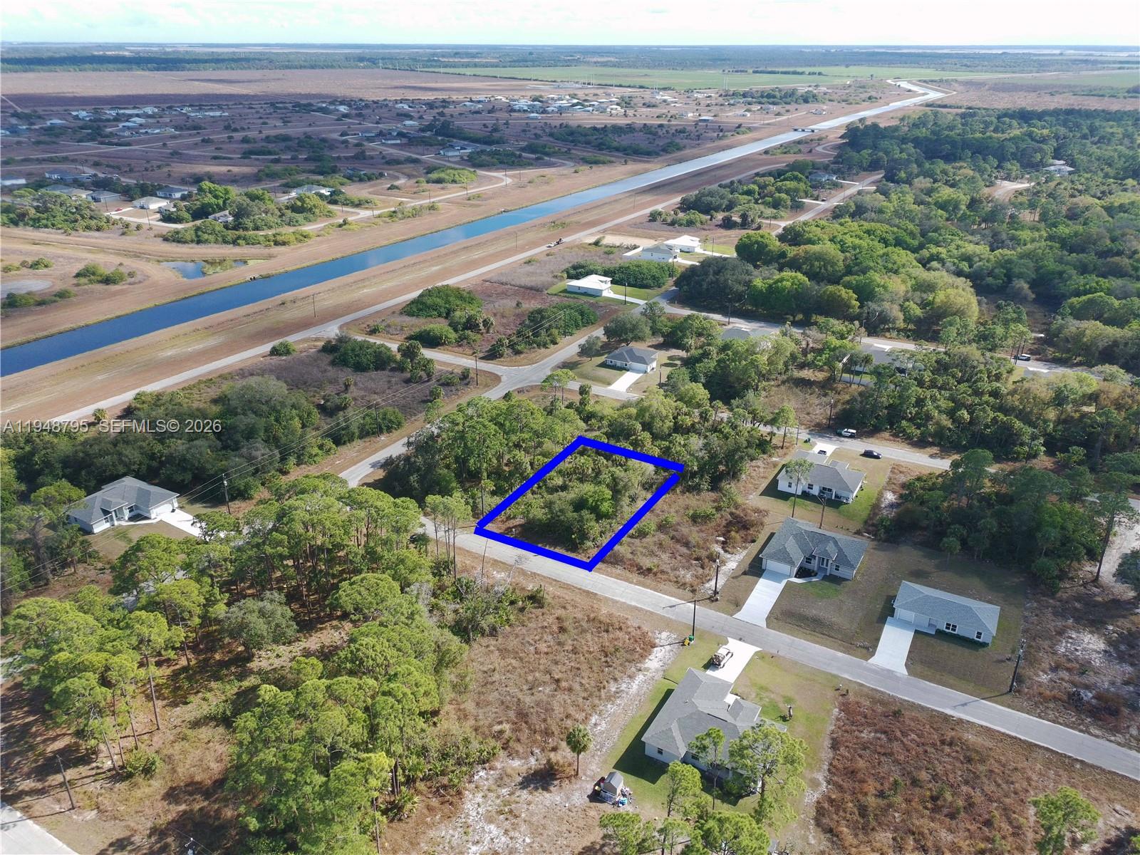 An aerial view shows a vacant, rectangular lot outlined in blue within a residential neighborhood — 315 Ivanhoe Ave, La Belle FL 33935, LA BELLE, FL