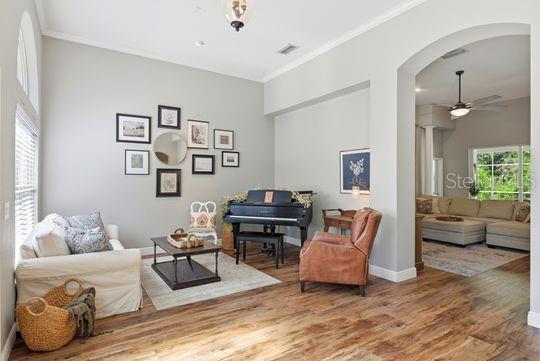 A living room features a piano, a sofa, a leather armchair, and a gallery wall — 197 NANDINA TERRACE, WINTER SPRINGS, FL