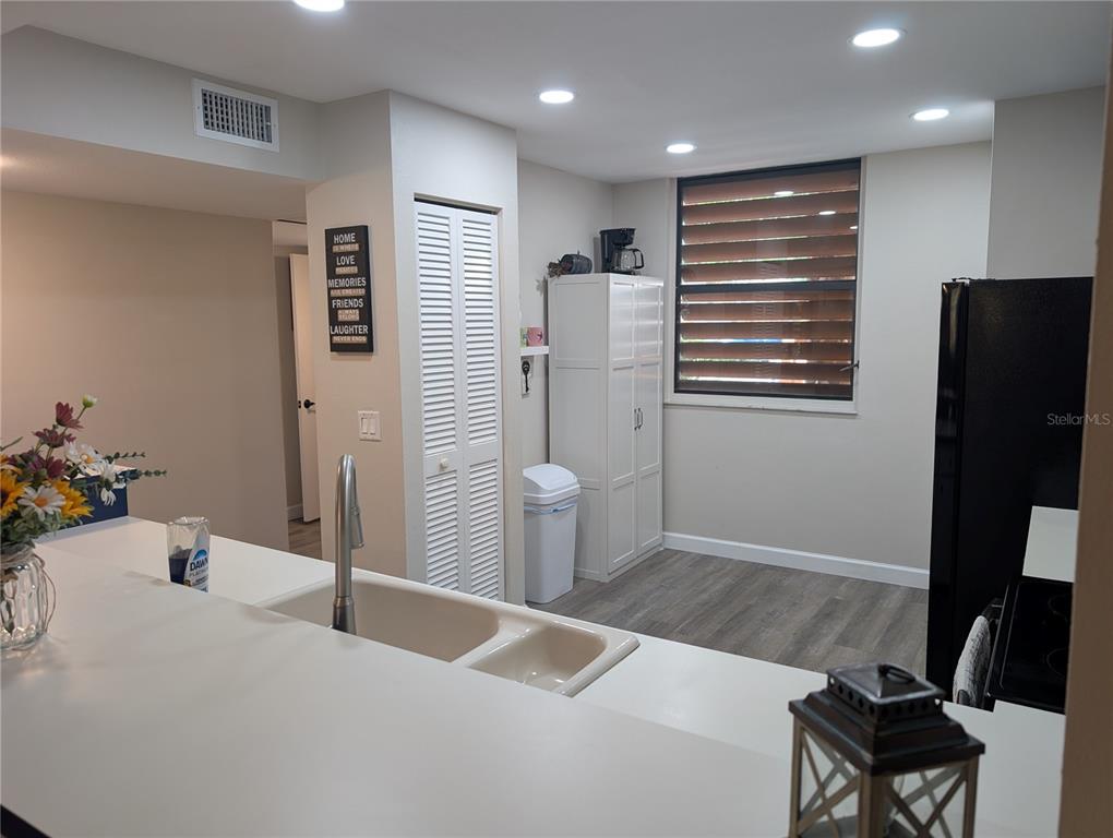 A kitchen features white countertops, a double sink, a tall pantry, and a black refrigerator — 135 WILD PALM DRIVE, BRADENTON, FL