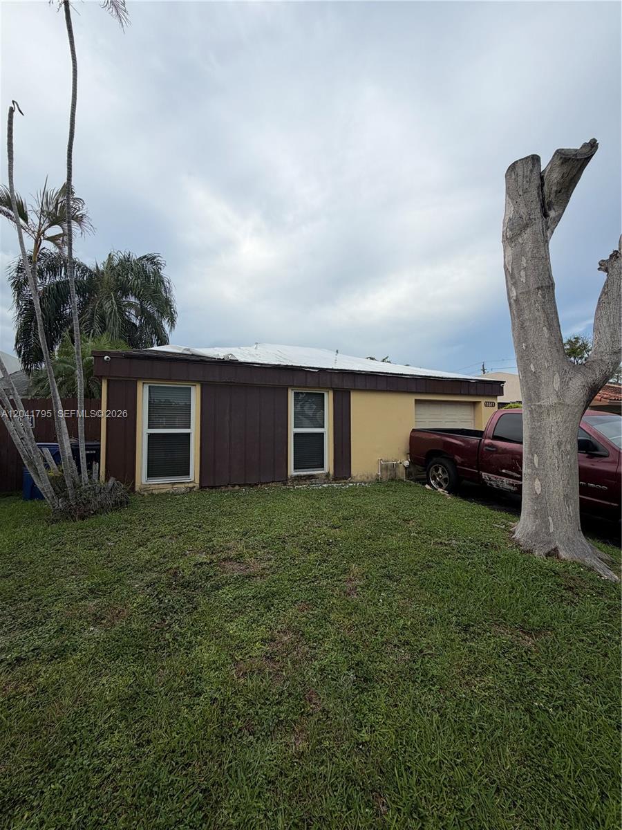 A single-story house with a brown facade, two windows, and a red pickup truck parked outside — 11511 SW 83rd Ter, Miami FL 33173, MIAMI, FL