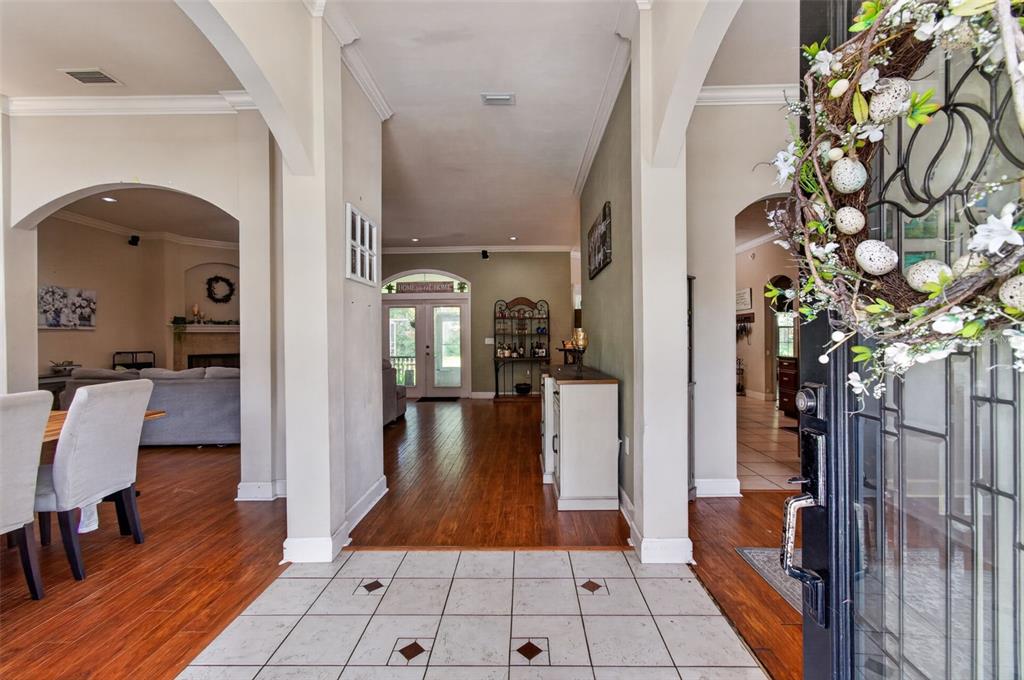 A tiled entryway leads into a home with hardwood floors, arched openings, and a glass door — 24865 NW 155TH AVENUE, HIGH SPRINGS, FL