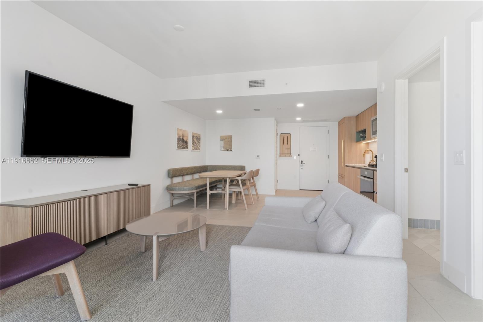This living room features a sofa, a dining nook with a bench, and a television — 159 NE 6th St # 4713, Miami FL 33132, MIAMI, FL