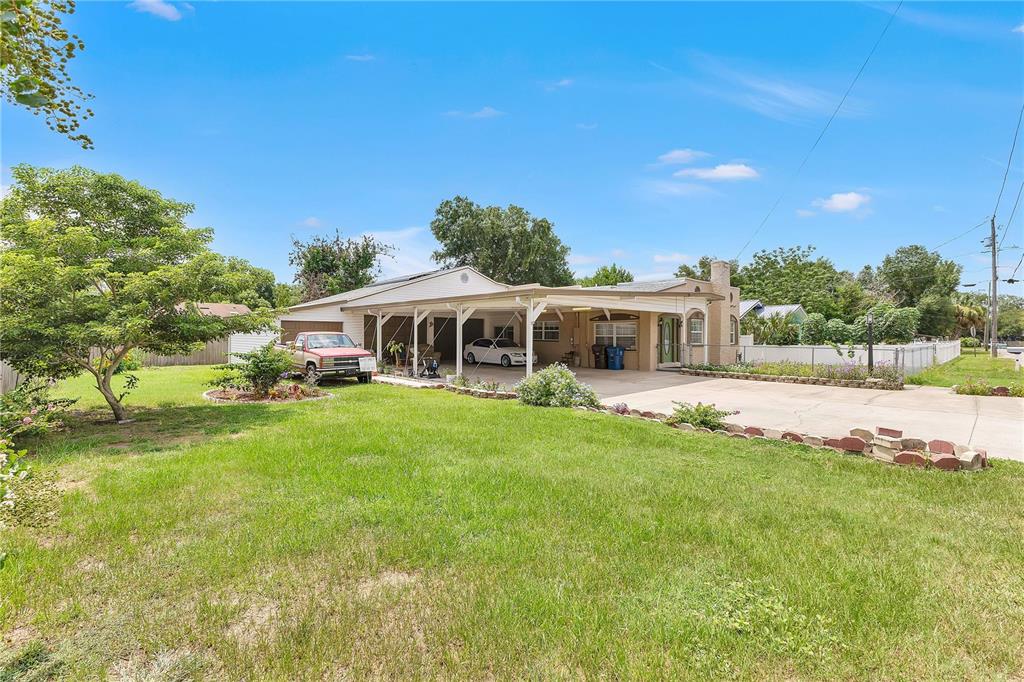 A single-story house with a large carport, a concrete driveway, and a grassy front yard — 205 TENNESSEE STREET, HAINES CITY, FL