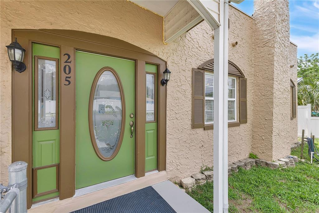 The exterior of a house features a green front door with a glass oval insert — 205 TENNESSEE STREET, HAINES CITY, FL