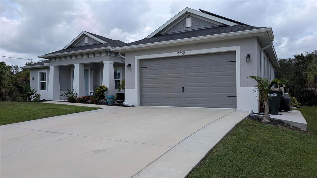 A single-story house with a gray garage, a covered front porch, and a concrete driveway — 3369 BILLBERRY STREET, NORTH PORT, FL