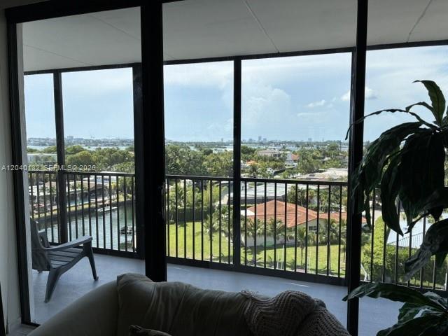 A view from a balcony overlooking a canal, lush greenery, and distant city buildings — 2500 NE 135th St # C611, North Miami FL 33181, NORTH MIAMI, FL