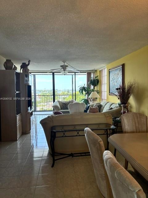 A living room with tile floors, a sofa, and a balcony overlooking the water — 2500 NE 135th St # C611, North Miami FL 33181, NORTH MIAMI, FL