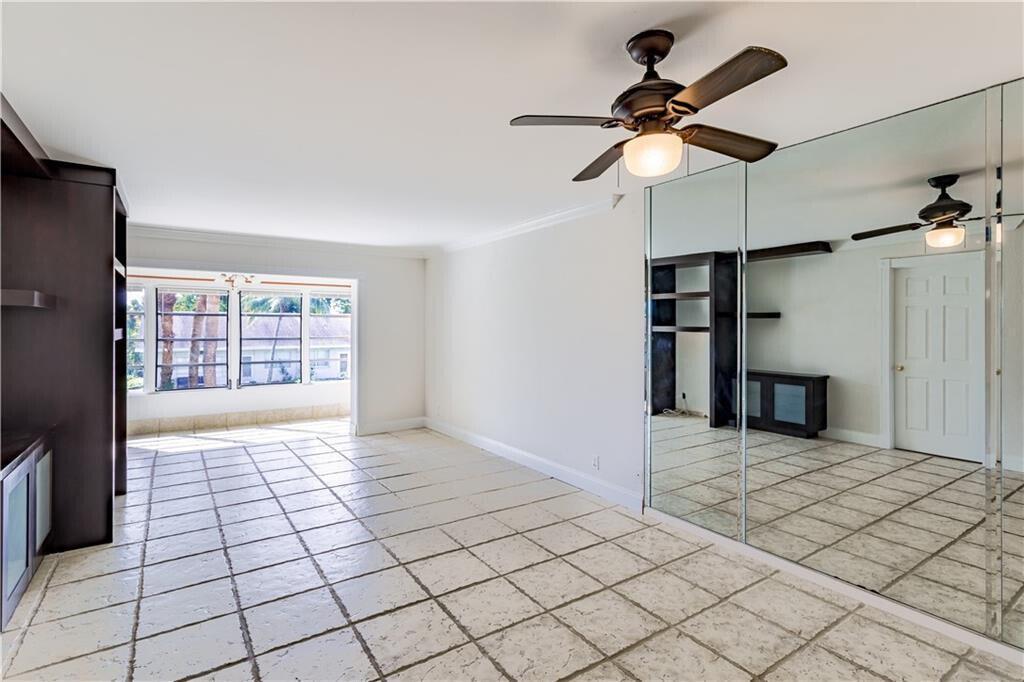 A room with tiled floors, a ceiling fan, and a wall of mirrored closet doors — 2800 Fiore Way # 2060, Delray Beach FL 33445, DELRAY BEACH, FL