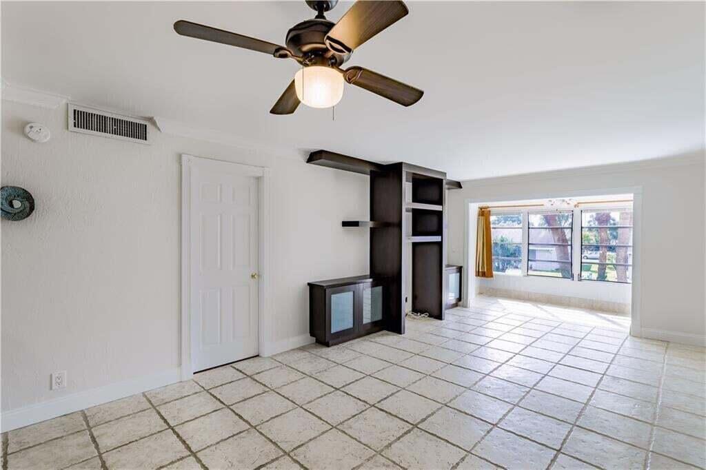 A room with white walls, tiled floors, a ceiling fan, and a dark wood shelving unit — 2800 Fiore Way # 2060, Delray Beach FL 33445, DELRAY BEACH, FL