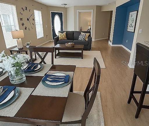 A dining area with a table and chairs overlooks a living room with a sofa — 2503 HASSONITE STREET, KISSIMMEE, FL