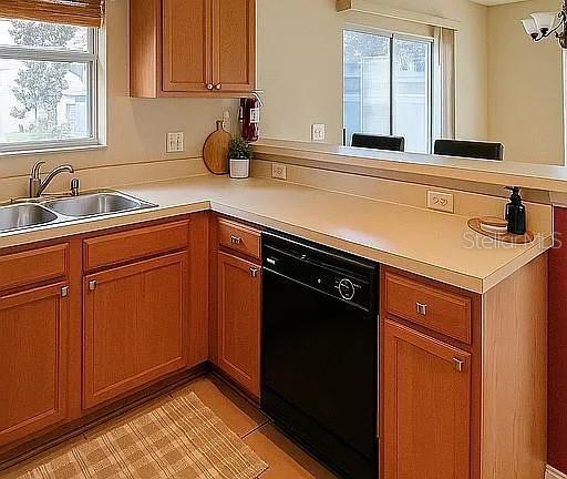A kitchen features light wood cabinets, a black dishwasher, and a double stainless steel sink — 2503 HASSONITE STREET, KISSIMMEE, FL