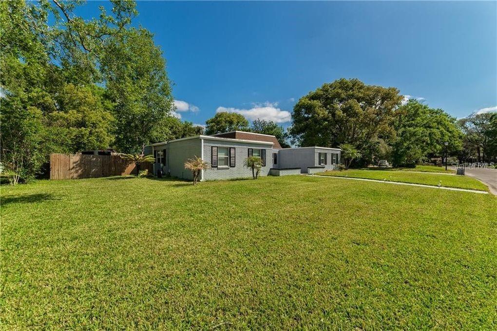 A single-story gray house with a flat roof sits on a large grassy lot — 130 VARIETY TREE CIRCLE, ALTAMONTE SPRINGS, FL
