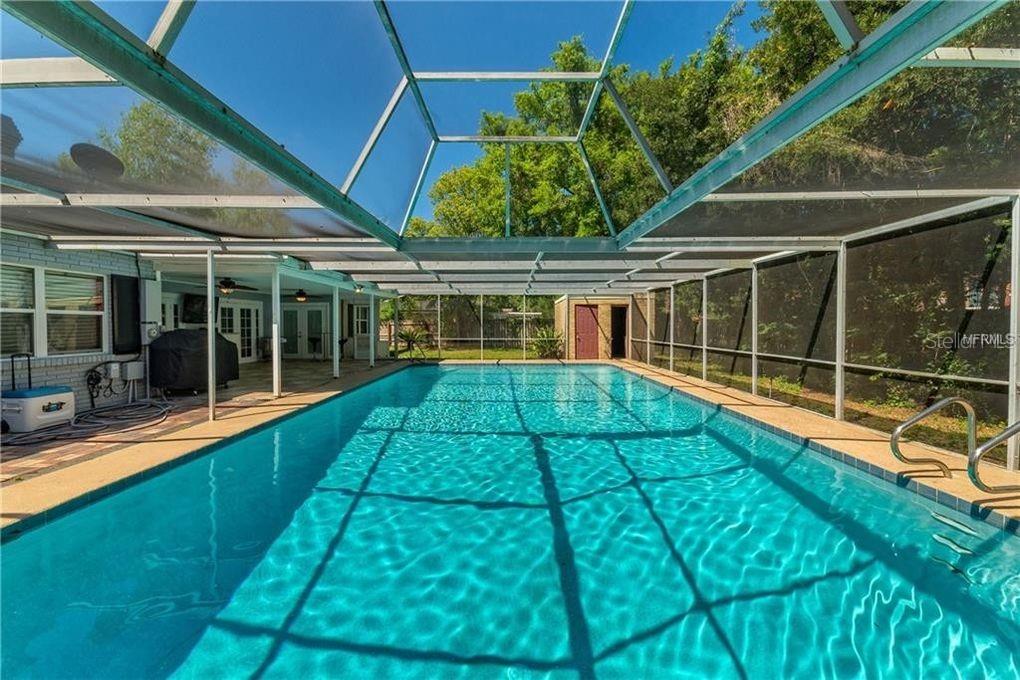 A rectangular swimming pool is enclosed by a screened lanai with a covered patio area — 130 VARIETY TREE CIRCLE, ALTAMONTE SPRINGS, FL