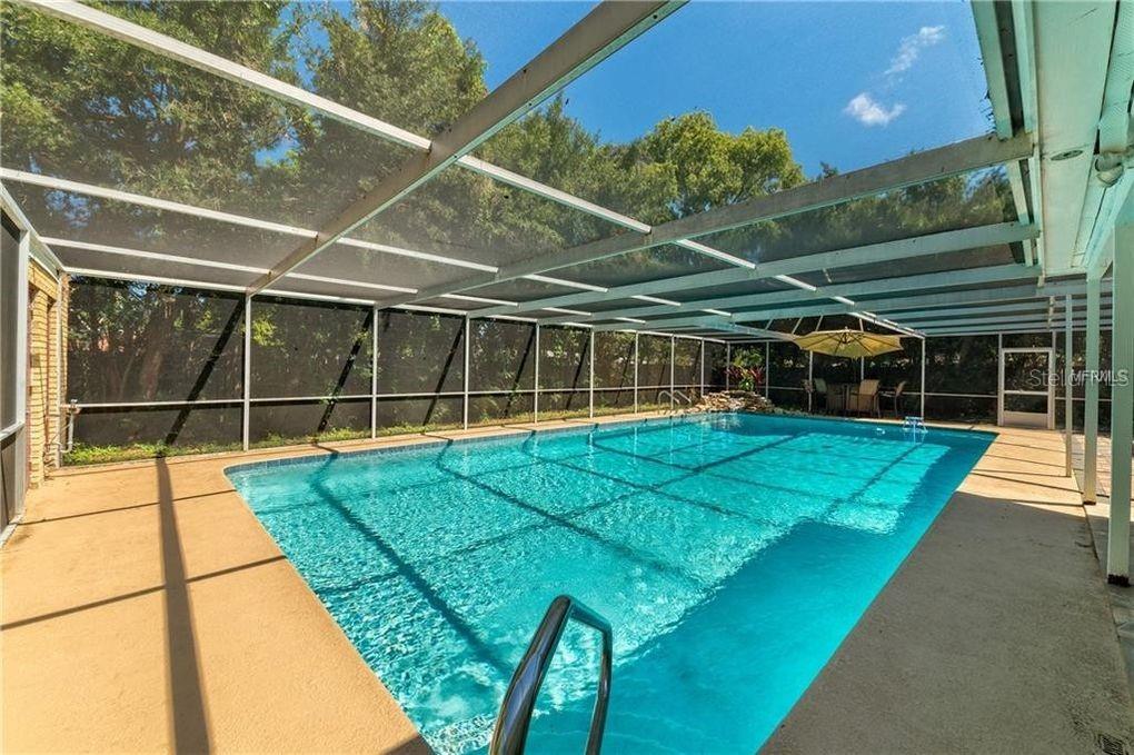A screened-in swimming pool with a concrete deck and a patio umbrella — 130 VARIETY TREE CIRCLE, ALTAMONTE SPRINGS, FL