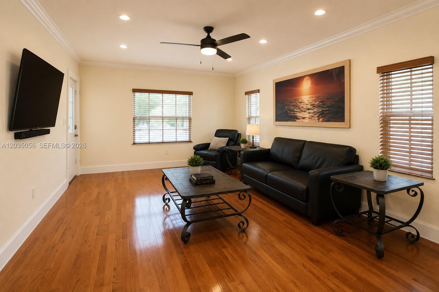 A living room features hardwood floors, a black sofa, a coffee table, and a ceiling fan — 316 S 24th Ave, Hollywood FL 33020, HOLLYWOOD, FL
