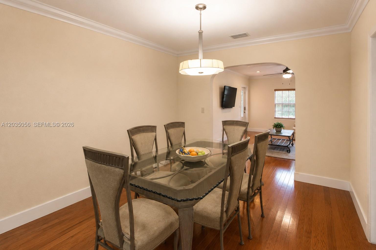 A dining room features a glass-topped table, six upholstered chairs, and hardwood flooring — 316 S 24th Ave, Hollywood FL 33020, HOLLYWOOD, FL