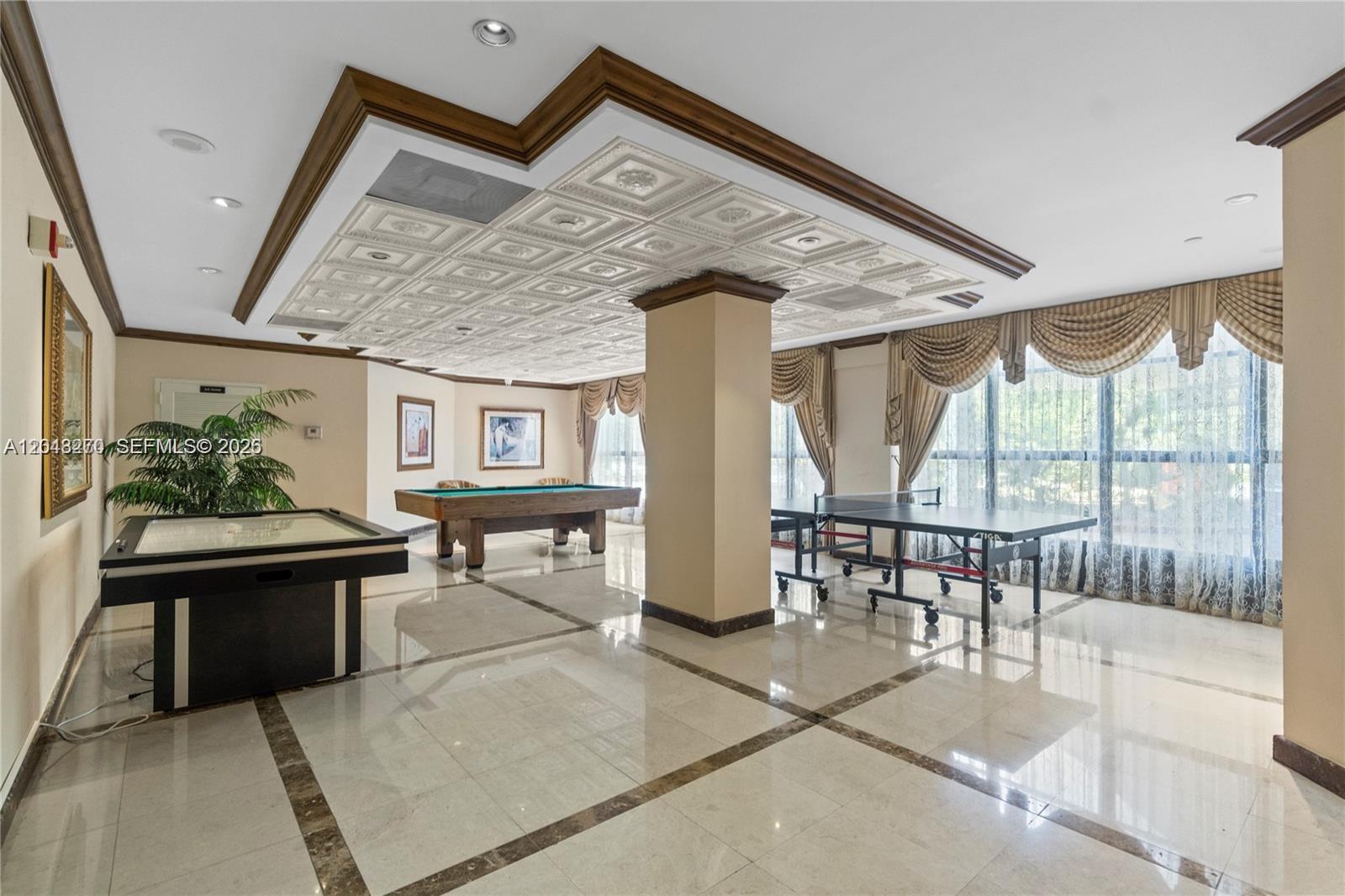 A game room features a pool table, ping pong table, air hockey table, and tiled ceiling — AVENTURA, FL