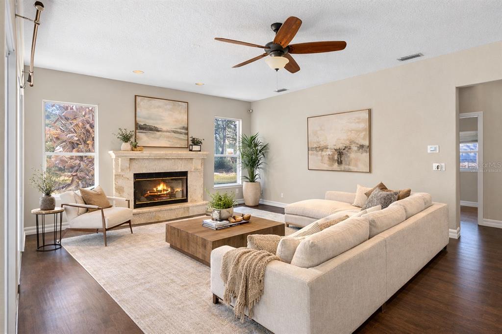 A living room features a stone fireplace, sectional sofa, wood coffee table, and ceiling fan — 19562 MAJESTIC STREET, ORLANDO, FL