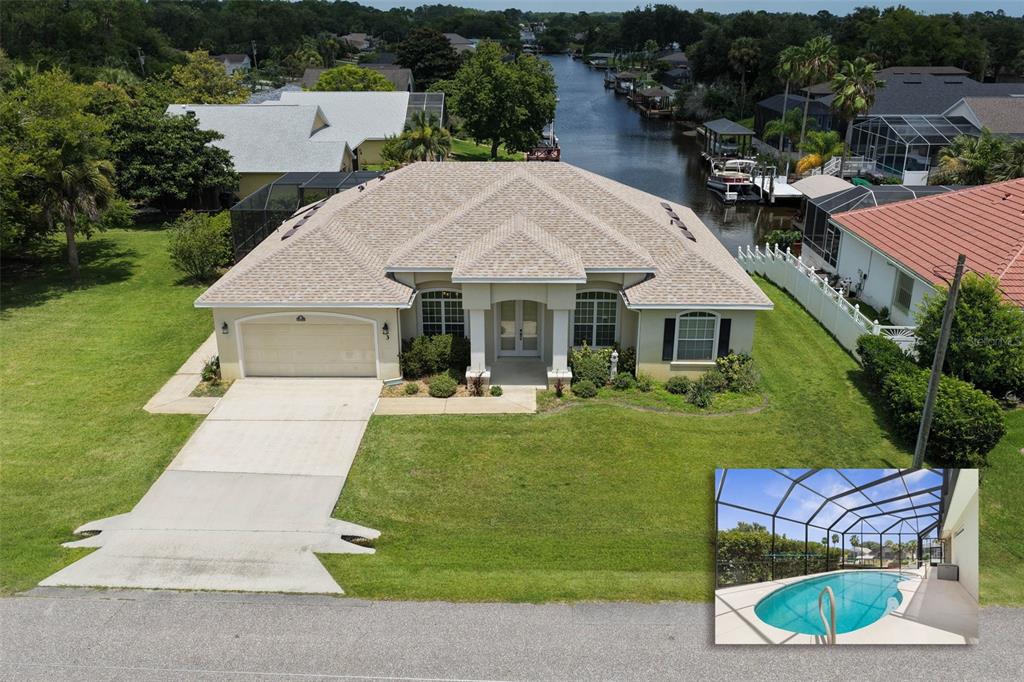 An aerial view of a single-story house with a pool enclosure and canal access — 3 COCHRAN LANE, PALM COAST, FL