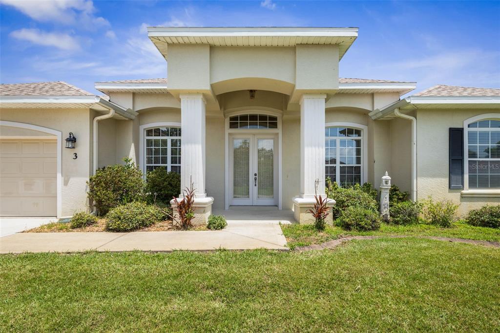 The exterior of a single-story house features a covered entryway with two white columns — 3 COCHRAN LANE, PALM COAST, FL