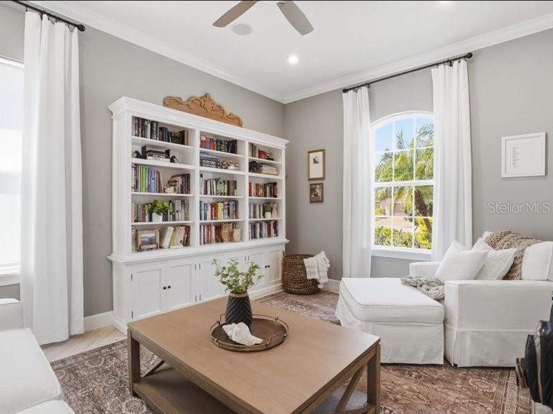 A living room features a large white built-in bookcase, a coffee table, and a chaise lounge — 6243 PLATEAU COURT, BRADENTON, FL