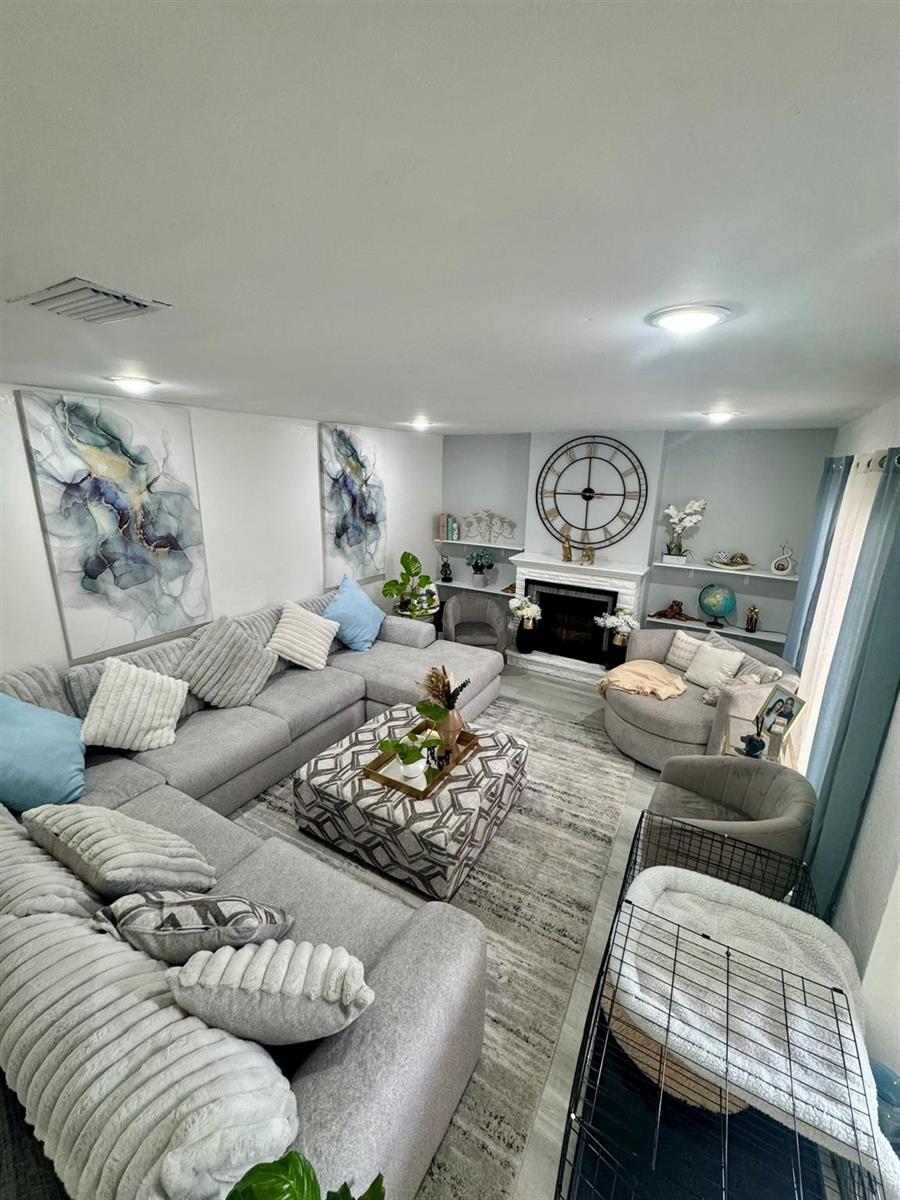 A living room features a large gray sectional, a patterned ottoman, and a fireplace — 4631 Cherry Road, West Palm Beach FL 33417, WEST PALM BEACH, FL