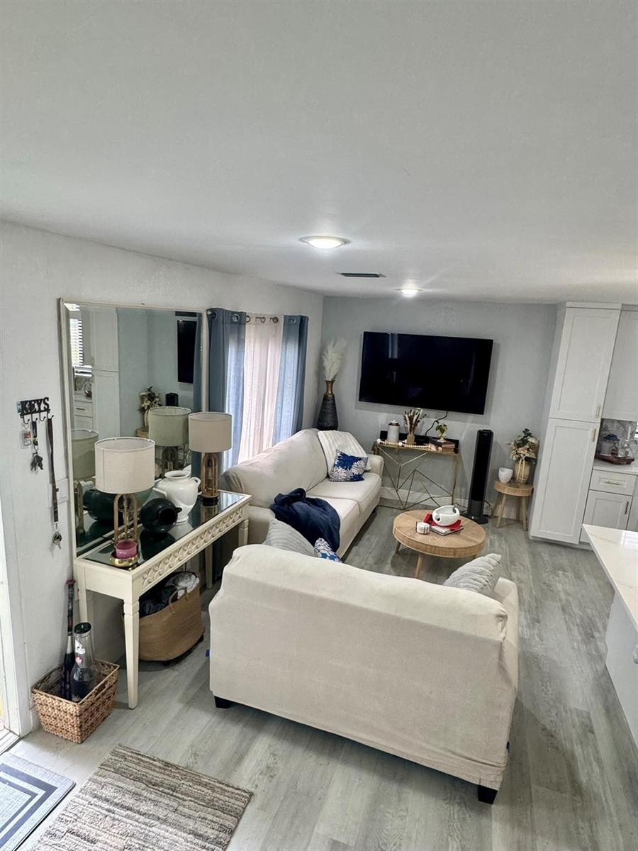 A living room features a white sofa, a round coffee table, and a mirrored console table — 4631 Cherry Road, West Palm Beach FL 33417, WEST PALM BEACH, FL