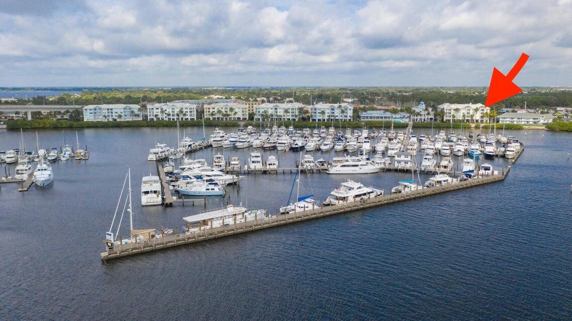 An aerial view shows a marina filled with boats in front of a waterfront apartment complex — 975 NW Flagler Avenue # 403, Stuart FL 34994, STUART, FL