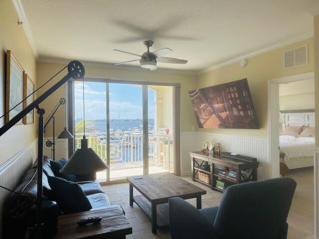A living room with a dark sofa, coffee table, and a balcony overlooking a marina — 975 NW Flagler Avenue # 403, Stuart FL 34994, STUART, FL