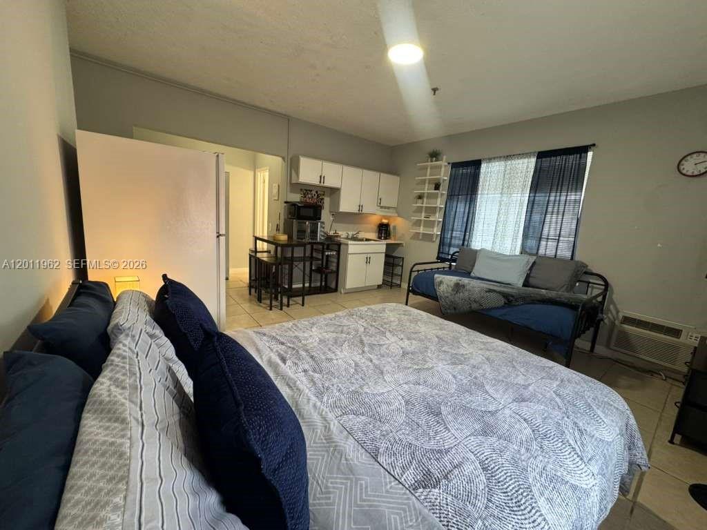A studio apartment features a bed, a daybed, and a small kitchenette with white cabinets — 3700 Collins Ave # 309, Miami Beach FL 33140, MIAMI BEACH, FL