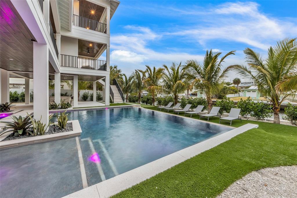 A multi-story house with a pool, lounge chairs, and palm trees in the backyard — 224 CHILSON AVENUE, ANNA MARIA, FL