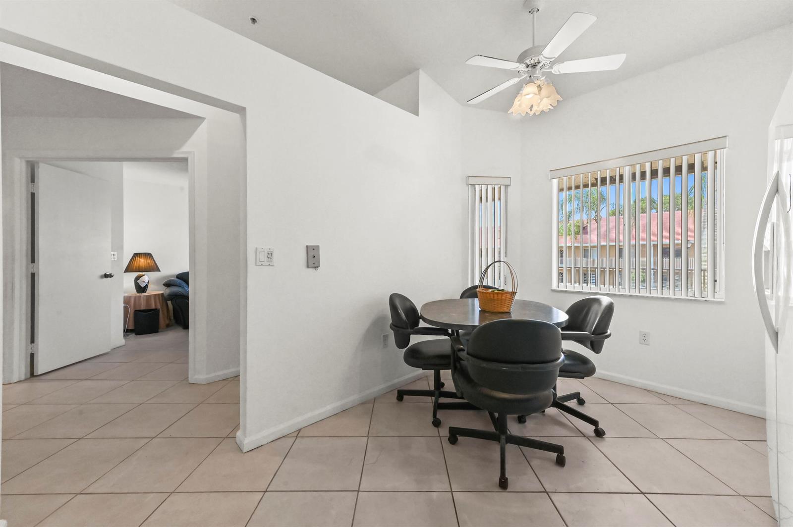 A dining area with a round table, four chairs, tile flooring, and a ceiling fan — 5952 Regal Glen Drive # 207, Boynton Beach FL 33437, BOYNTON BEACH, FL