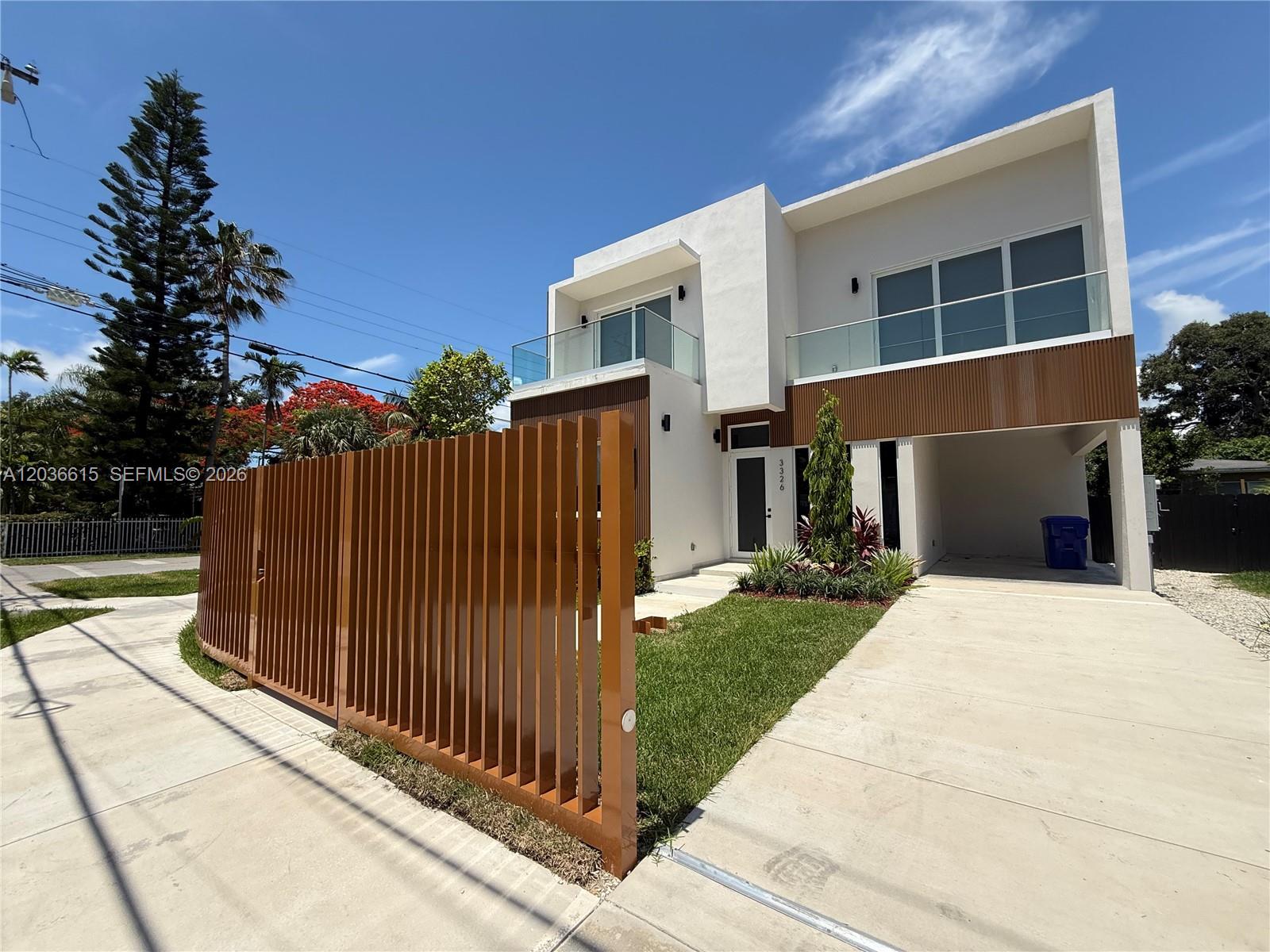 A modern two-story house features a slatted brown fence, glass balconies, and a concrete driveway — 3326 Elizabeth St, Miami FL 33133, MIAMI, FL