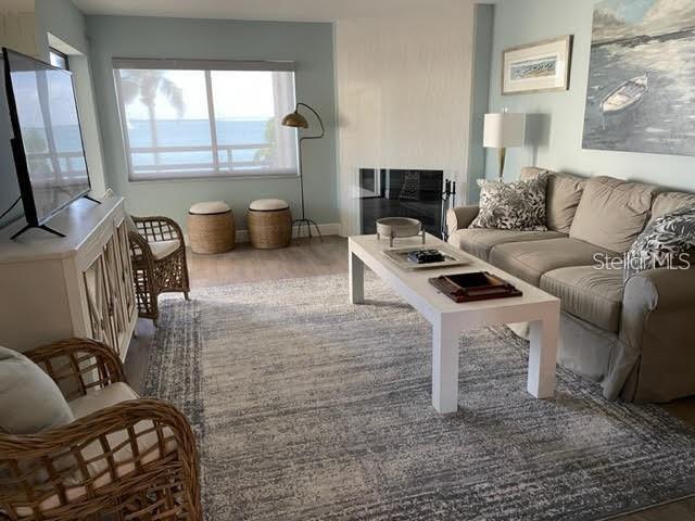 A living room features a beige sofa, a white coffee table, and a view of water — 113 1ST STREET E UNIT 103, TIERRA VERDE, FL
