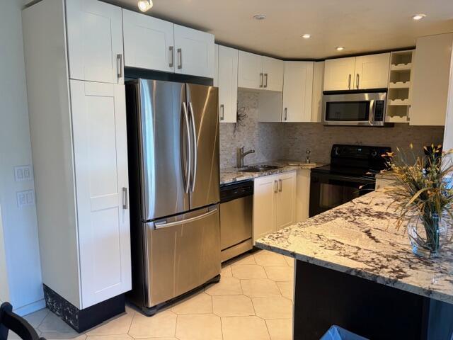 A kitchen features white cabinets, stainless steel appliances, and a granite-topped island — 4008 Birkshire A # 4008, Deerfield Beach FL 33442, DEERFIELD BEACH, FL