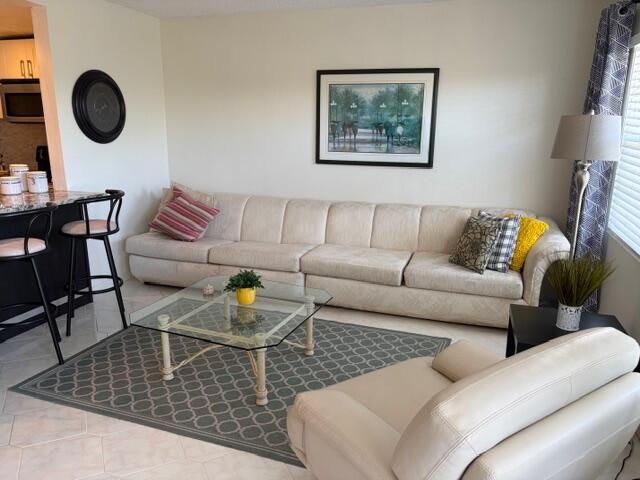 A living room features a long beige sofa, a glass coffee table, and an armchair — 4008 Birkshire A # 4008, Deerfield Beach FL 33442, DEERFIELD BEACH, FL
