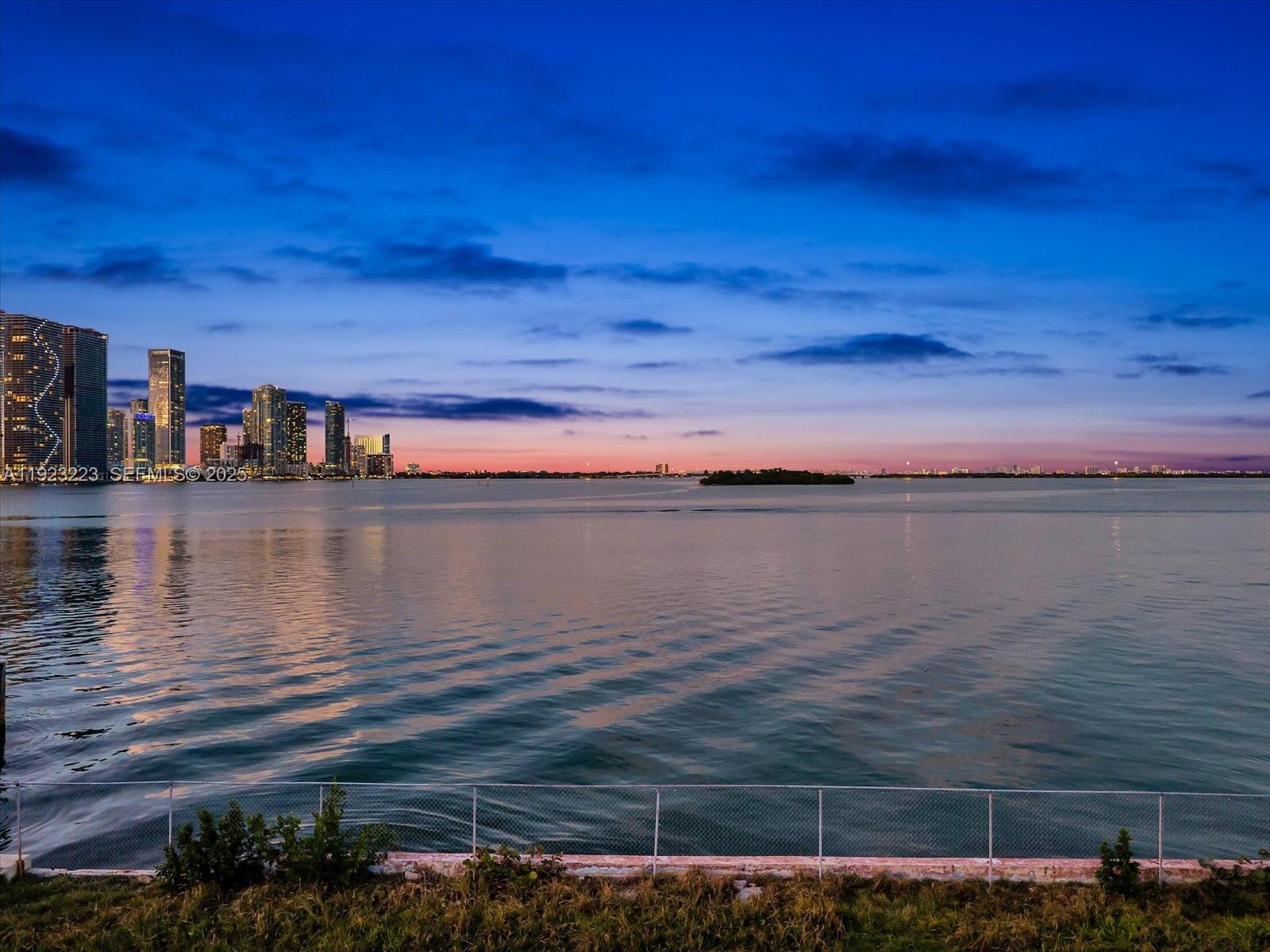 A view of a city skyline across a body of water at dusk — 851 N Venetian Dr, Miami FL 33139, MIAMI, FL