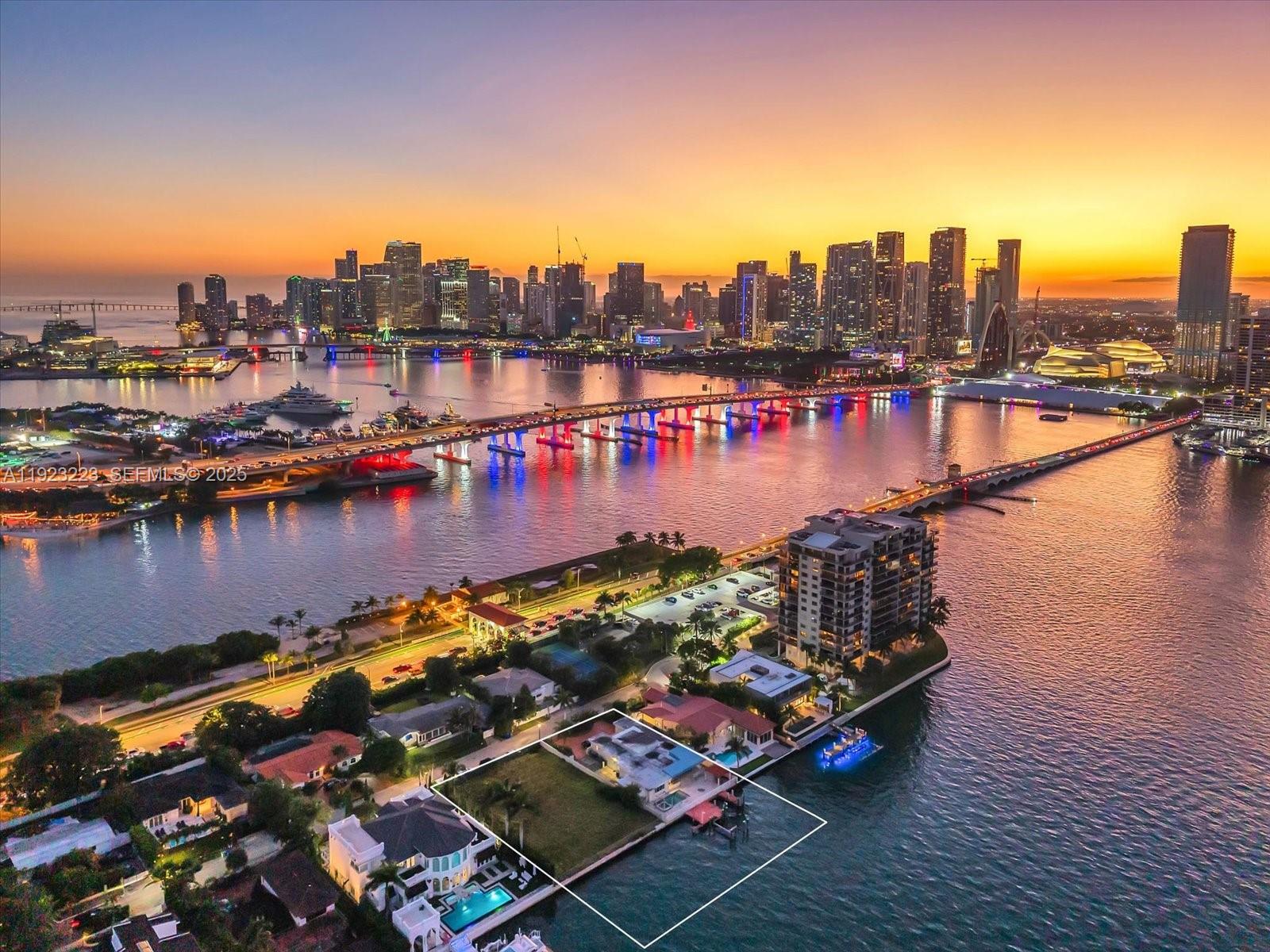 An aerial view shows a waterfront house with a large yard and dock at sunset — 851 N Venetian Dr, Miami FL 33139, MIAMI, FL