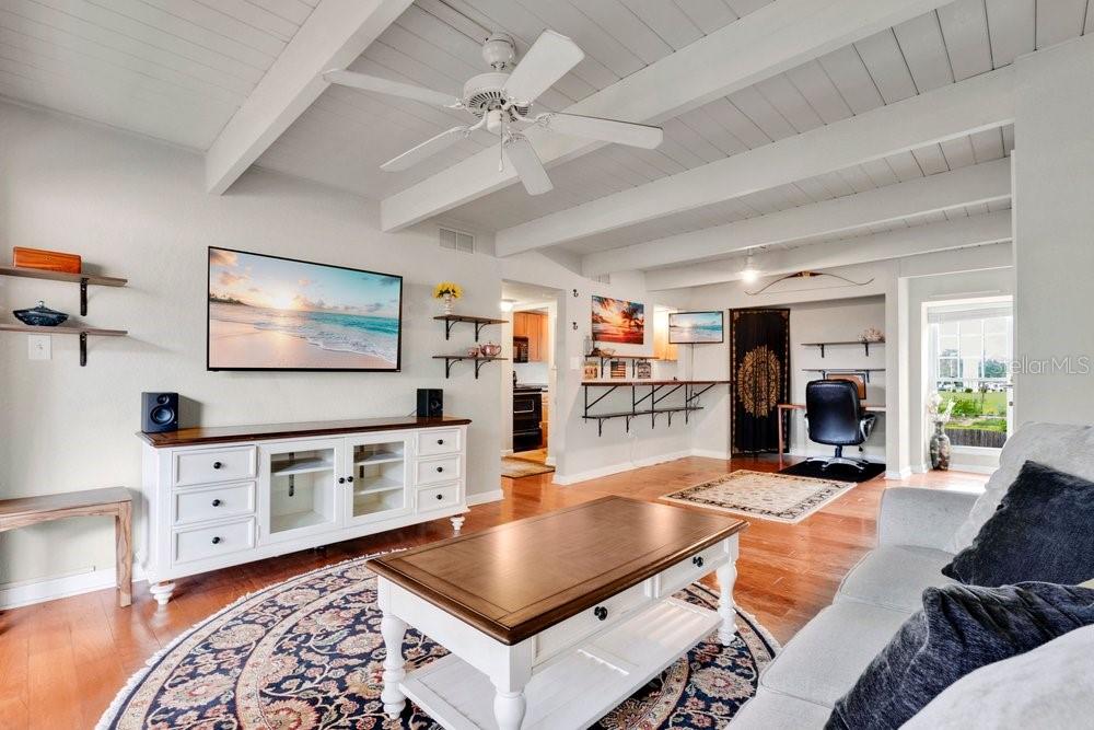 A living room with a white media console, wooden coffee table, and exposed ceiling beams — 792 E MICHIGAN STREET UNIT 14, ORLANDO, FL