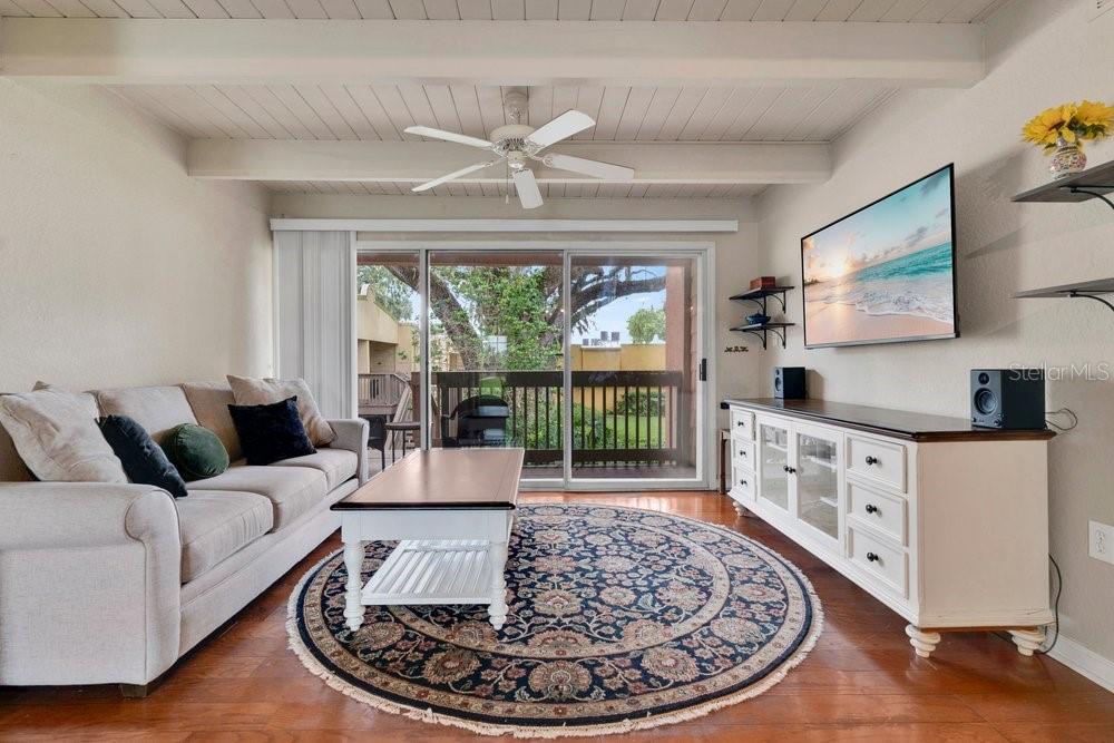 A living room features a sofa, round rug, coffee table, media console, and sliding glass doors — 792 E MICHIGAN STREET UNIT 14, ORLANDO, FL
