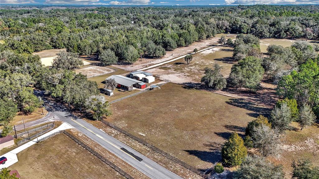 An aerial view shows a rural property with a house, outbuildings, and fenced pastures — 11375 N CIRCLE M AVENUE, DUNNELLON, FL