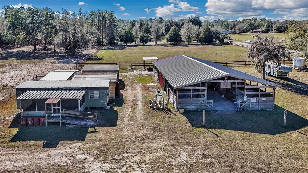 An aerial view shows a mobile home and a large barn on a grassy lot — 11375 N CIRCLE M AVENUE, DUNNELLON, FL