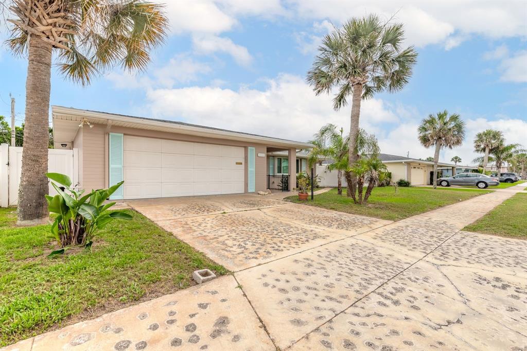 A single-story house with a beige exterior, a two-car garage, and palm trees in front — 2315 BONNIE VIEW DRIVE, ORMOND BEACH, FL