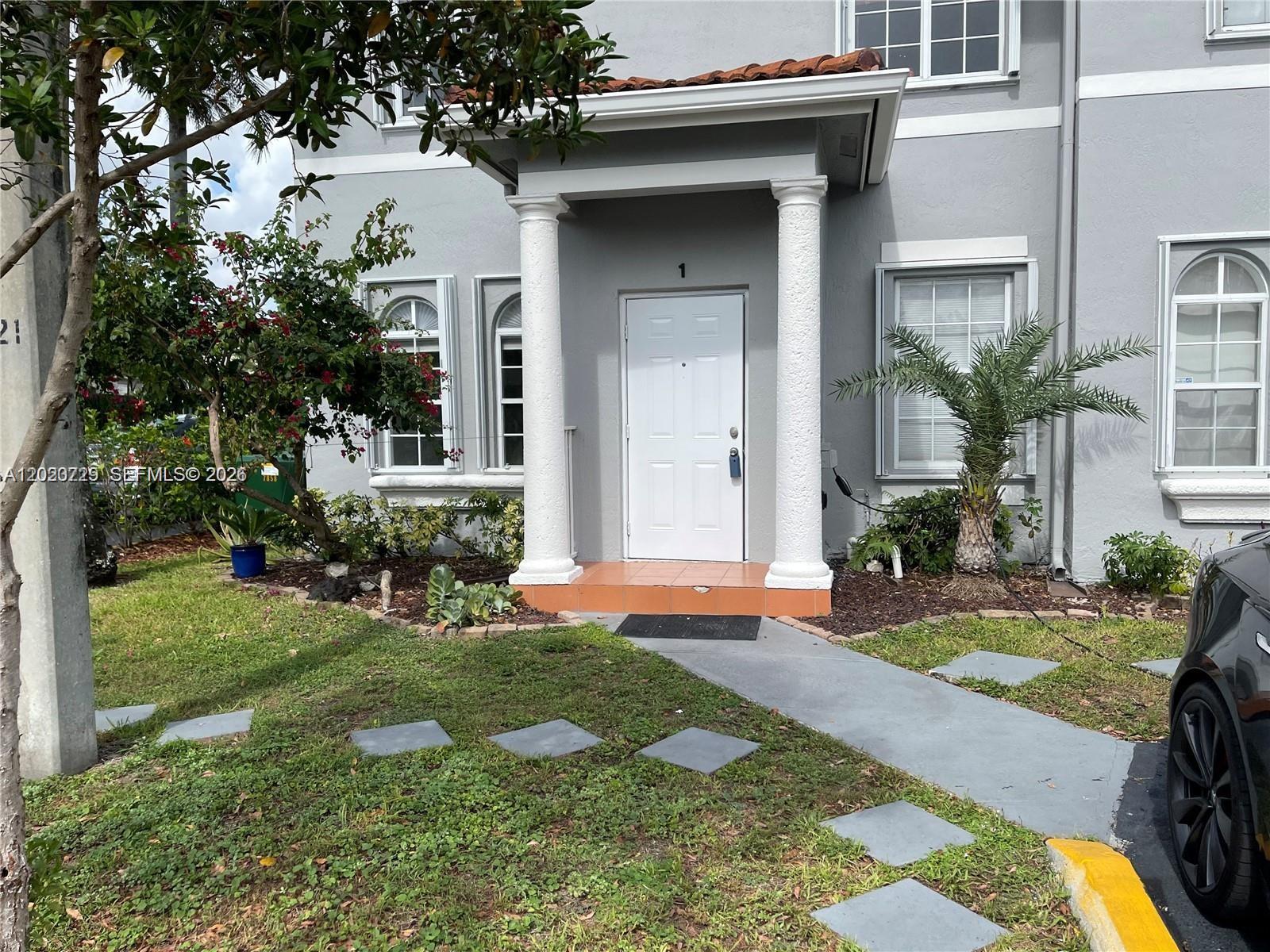 The exterior of a gray two-story house features a white front door with columns — 5200 NW 109th Ave # 1, Doral FL 33178, DORAL, FL