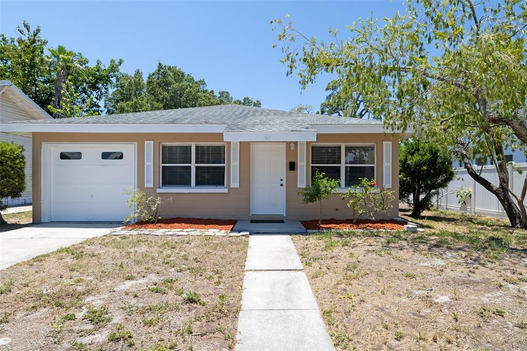 A single-story house with a tan exterior, white trim, a garage, and a front walkway — 808 26TH STREET W, BRADENTON, FL