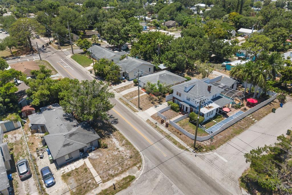 An aerial view shows several houses along a residential street with trees and vehicles — 808 26TH STREET W, BRADENTON, FL