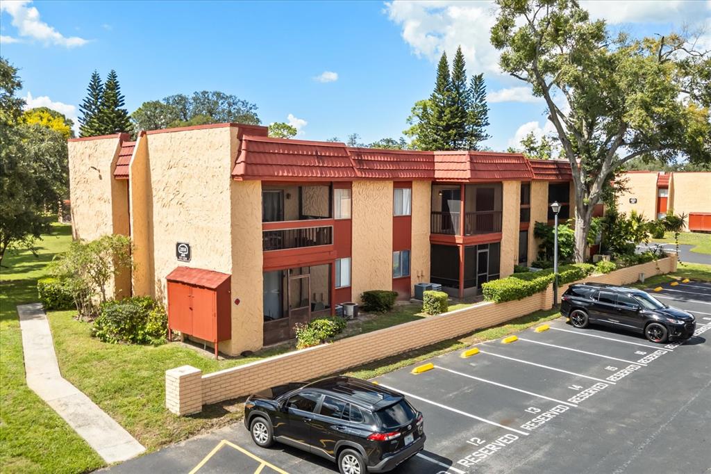 An exterior view of a two-story apartment building with a parking lot in front — 2858 N POWERS DRIVE UNIT 123, ORLANDO, FL