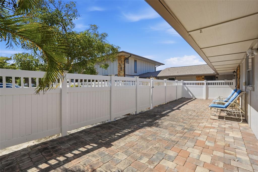 A paved patio features a white vinyl privacy fence and two lounge chairs — 4289 ISLAND CIRCLE UNIT 1, FORT MYERS, FL