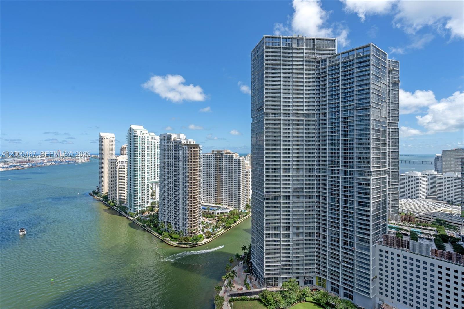 An aerial view shows several tall residential skyscrapers situated along a waterfront in a city — 200 Biscayne Boulevard Way # 3407, Miami FL 33131, MIAMI, FL